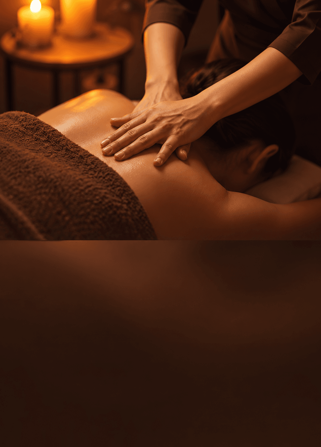Chuyên viên massage lưng cho khách bên ánh nến